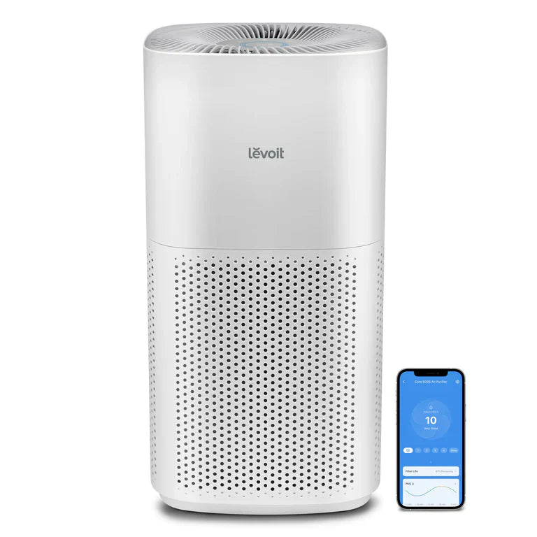 A white LEVOIT Core 600S Smart Air Purifier with a circular design, featuring a grille on the front and a smartphone app interface displayed next to it indicating air quality.