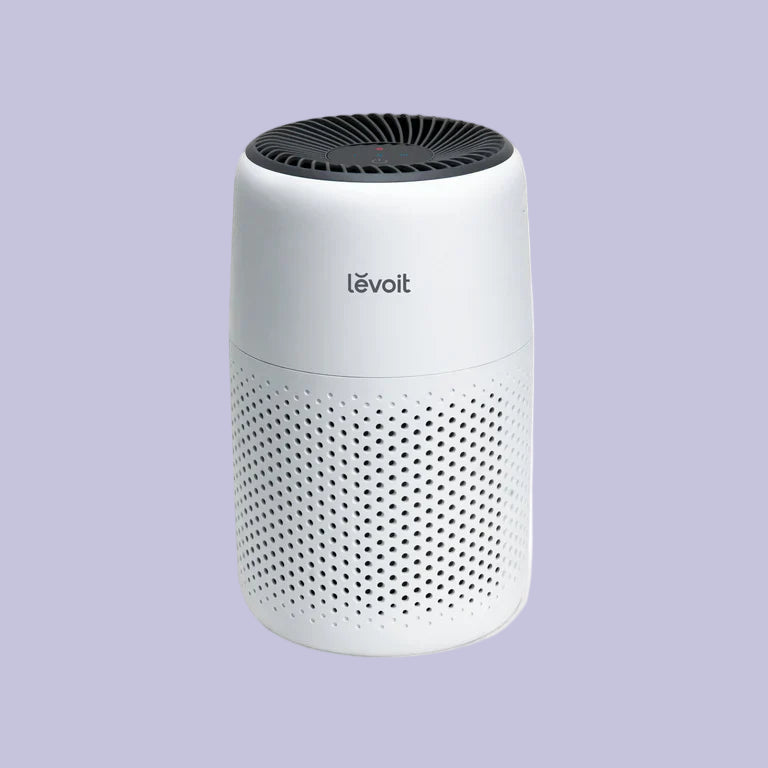 A white LEVOIT Core Mini Air Purifier with a cylindrical shape and a black air outlet at the top.